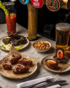 una mesa cubierta con platos de comida y bebida en The William, en Londres