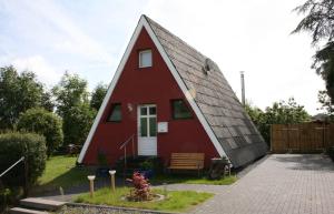 een rood huis met een schuin dak bij Eifelferienhaus Wald- und Wiesenblick in Dockweiler