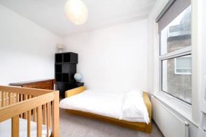 a small bedroom with a bed and a window at Charming 3BR Family-Friendly London Home in London