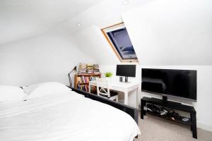 um quarto com uma cama e uma televisão de ecrã plano em Charming 3BR Family-Friendly London Home em Londres