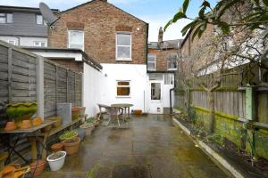 a patio with a table and chairs and a fence at Charming 3BR Family-Friendly London Home in London