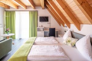 Un dormitorio con 2 camas y un escritorio en una habitación. en Adler Landhotel, en Buergstadt