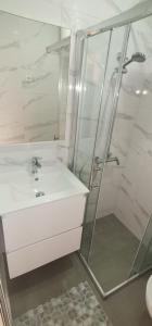 a white bathroom with a sink and a shower at Apartment with large terrace 3558-4 in Žuljana
