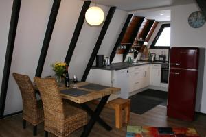 eine Küche mit einem Tisch und Stühlen sowie einem Kühlschrank in der Unterkunft Eifelferienhaus Wald- und Wiesenblick in Dockweiler