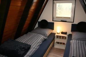 two beds in a room with a window at Eifelferienhaus Wald- und Wiesenblick in Dockweiler