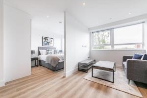 Sala de estar blanca con cama y sofá en Bright and Modern Studio Apartment in East Grinstead en East Grinstead