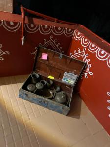 een houten doos gevuld met vazen op een vloer bij Prag View Heritage Homestay in Bhuj