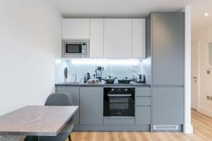 uma cozinha com utensílios de aço inoxidável e uma mesa em Lovely Bright Studio Apartment in Central East Grinstead em East Grinstead