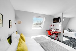 a white bedroom with a bed and a desk at Hotel Acadia - Astotel in Paris