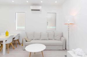 a white living room with a couch and a table at We Madrid Casa Arriaza in Madrid