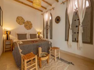 Riad Nelia De Marrakech Hotel Boutique & Spa في مراكش: غرفة نوم بسرير وطاولة وكراسي