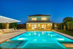 a swimming pool in front of a house at Serenity Zante in Makris Gialos