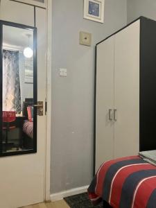 1 dormitorio con espejo junto a la cama en Private stay @ London-Stratford., en Londres