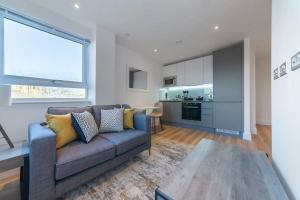 a living room with a couch and a kitchen at Modern Studio Apartment in East Grinstead in East Grinstead