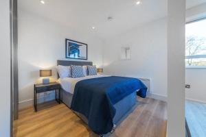 um quarto com uma cama com um cobertor azul em Modern Studio Apartment in East Grinstead em East Grinstead