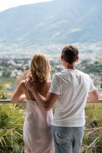 mężczyzna i kobieta stojący na szczycie wzgórza w obiekcie Boutique Hotel Eschenlohe w mieście Schenna