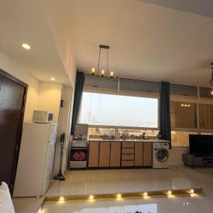 a kitchen with a large window and a refrigerator at Red Sea Studio Partial Sea View استديو بحر الأحمر اطلالة جزئية in Jeddah