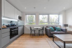 cocina y sala de estar con sofá y mesa en Contemporary Studio Apartment in East Grinstead, en East Grinstead