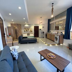 a living room with a blue couch and a kitchen at Red Sea Studio Partial Sea View استديو بحر الأحمر اطلالة جزئية in Jeddah