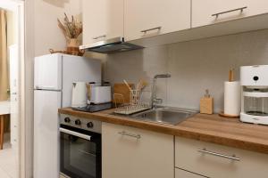 a kitchen with a sink and a refrigerator at Zefyros Apartments in Skala Rachoniou