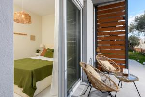 a room with a balcony with a bed and chairs at Zefyros Apartments in Skala Rachoniou