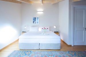 um quarto com uma cama branca e um vaso em boo premium living ioannina em Anatolí