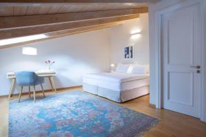 um quarto com uma cama branca e um tapete azul em boo premium living ioannina em Anatolí