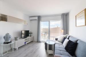 a living room with a couch and a tv at Quimanna Calafell Beach in Calafell