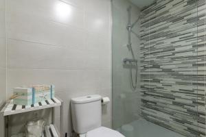 a bathroom with a toilet and a glass shower at Quimanna Calafell Beach in Calafell +4 photos