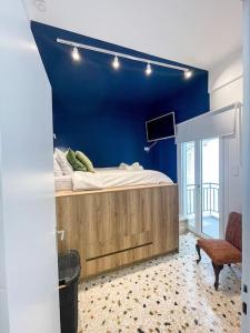 a bedroom with a bed with a blue wall at Apartment near Metro + Port in Piraeus