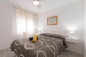 a bedroom with a bed with a yellow pillow on it at Quimanna Calafell Beach in Calafell