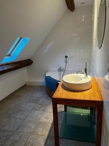 a bathroom with a sink on a wooden table at Les Janets 12 personnes in Saint-Sauveur-en-Puisaye