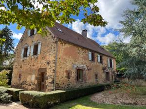 an old stone building with a roof at Les Janets 12 personnes in Saint-Sauveur-en-Puisaye