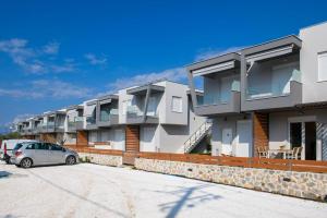 a row of apartment buildings in a parking lot at Zefyros Apartments in Skala Rachoniou +10 photos