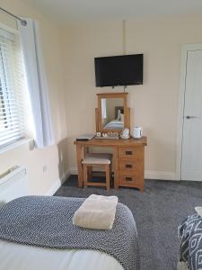 1 dormitorio con cama y escritorio con espejo en Celtic Minor Stables, en Swansea