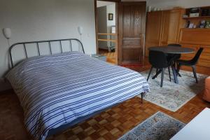 a bedroom with a bed and a table and chairs at Logeren in Aldeneik in Maaseik