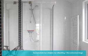 y baño con ducha y espejo. en Siblu camping Lauwersoog en Lauwersoog
