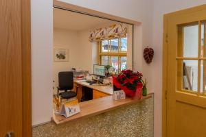 an office with a desk with a computer and a mirror at Gästehaus Haffner in Zell am See