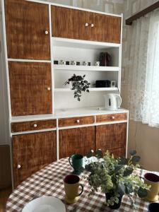 a kitchen with a table and a cabinet with plants on it at Mamma maja in Kiviõli