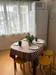 a table with four chairs and a refrigerator in a kitchen at Mamma maja in Kiviõli +66 photos