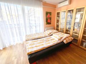 a bedroom with a bed and a large window at Lovely home - Free parking in Budapest