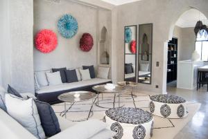 - un salon avec un canapé et deux tables dans l'établissement Palais Laawina, à Marrakech