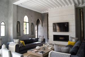 - un salon avec un canapé et une cheminée dans l'établissement Palais Laawina, à Marrakech