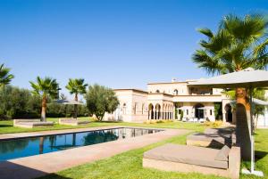 une demeure de caractère avec piscine et palmiers dans l'établissement Palais Laawina, à Marrakech
