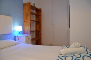 um quarto com uma cama branca e uma parede azul em Casa en Mirador del Codolar em Tossa de Mar