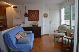 uma sala de estar com um sofá azul e uma cadeira em Casa en Mirador del Codolar em Tossa de Mar