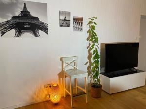 uma sala de estar com uma televisão e um vaso de plantas em Altbau mit Flair em Klagenfurt