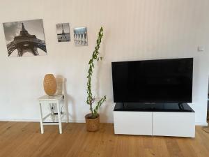 ein Wohnzimmer mit einem Flachbild-TV auf einem weißen Schrank in der Unterkunft Altbau mit Flair in Klagenfurt am Wörthersee