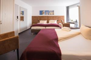 two beds in a hotel room with two bedsvisor at Hotel Residenz in Ravensburg