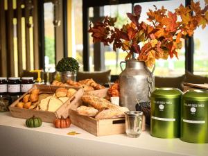 - une table avec un plateau de différents types de pain dans l'établissement ibis Beaune La Ferme Aux Vins, à Beaune